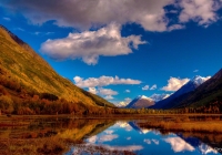 The fall colors of Tern Lake with still waters reflecting the beauty of Alaska.	